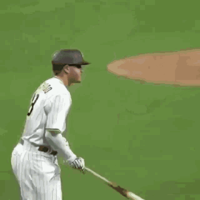 a baseball player is running on a field with a bat .