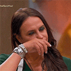 a woman is covering her mouth with her hand while wearing a watch on her wrist .