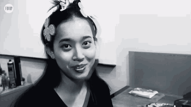 a black and white photo of a woman with a flower in her hair and the word fever on the bottom