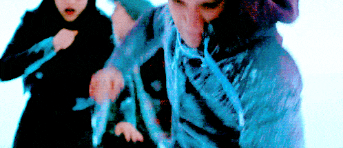 a man in a blue sweater is being pulled by a woman