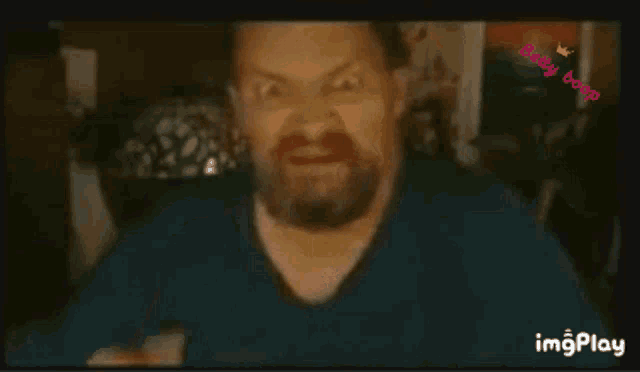a man with a beard is making a funny face and giving the middle finger