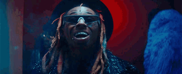 a man with dreadlocks wearing sunglasses and a hat