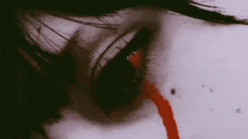 a close up of a woman 's eye with blood coming out of it