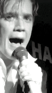 a close up of a person singing into a microphone .