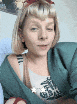 a woman with blonde hair is wearing a green jacket and a white shirt