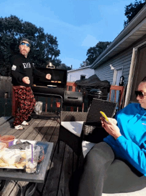 a man wearing a black shirt that says da on it is grilling