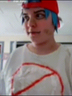 a person with blue hair is wearing a red hat and a white shirt with a red circle on it