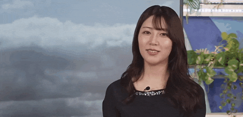 a woman in a black dress with a microphone in her neck