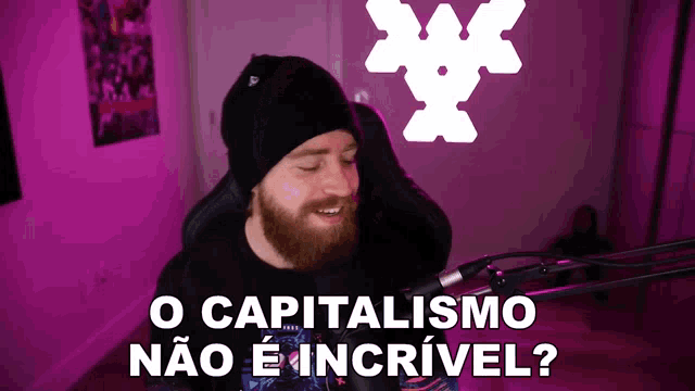 a man with a beard stands in front of a microphone with the words o capitalismo não e incrivel