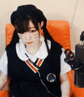 a girl is sitting in a chair wearing headphones and a beret .