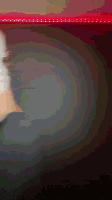 a blurry picture of a person 's face with a red light behind them