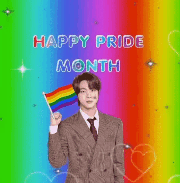 a man in a suit and tie is holding a rainbow flag in front of a colorful background .