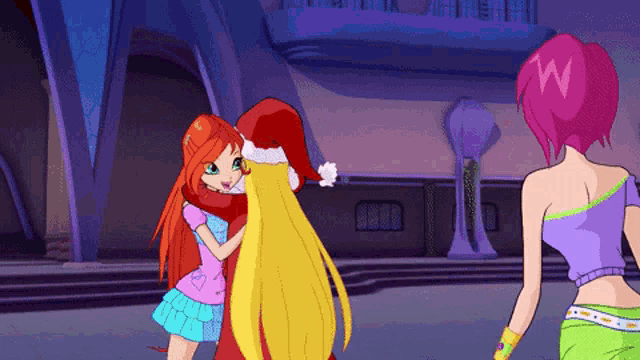 a girl in a santa hat is hugging another girl in front of a building