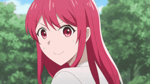a girl with red hair is smiling in front of trees