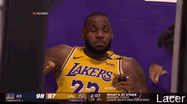 a man wearing a lakers jersey looks at something