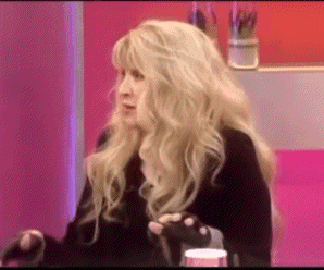 a woman with long blonde hair is wearing black gloves and a black coat .