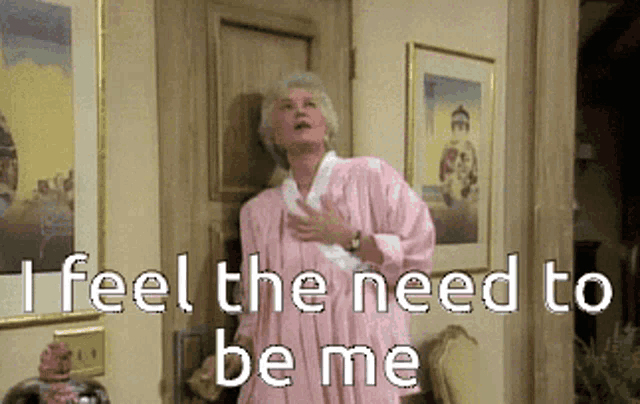 a woman in a pink robe is standing in front of a door with the words " i feel the need to be me " above her