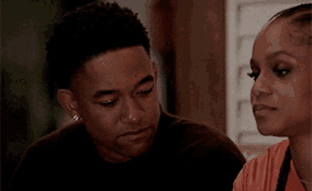 a man and a woman are looking at each other in a room .