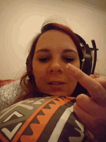 a woman wearing headphones is laying on a pillow with a geometric pattern on it