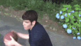 a man in a blue shirt is holding a football in his hands