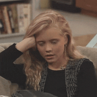 a young woman sitting on a couch with her hand on her head