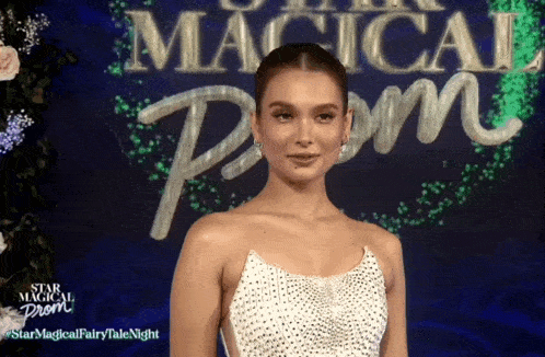 a woman in a white dress is standing in front of a sign that says " star magical prom "