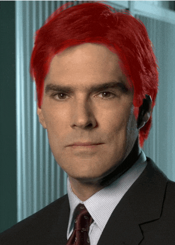 a man with red hair and a suit and tie
