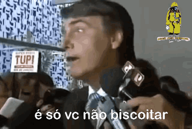 a man speaking into a microphone with the words e so vc nao biscoitar written below him