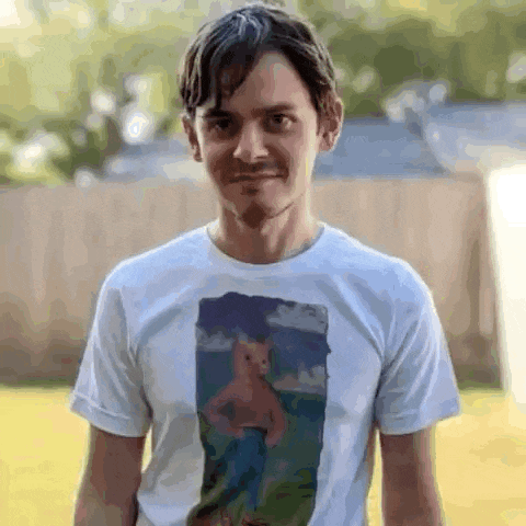 a man wearing a white t-shirt with a picture of spongebob squarepants on it is smiling .