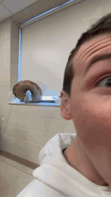 a man making a funny face in front of a window