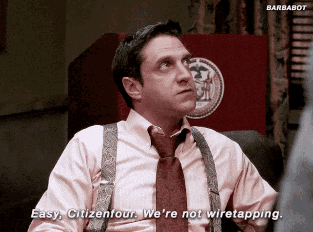 a man in a pink shirt and red tie says " easy citizenfour we 're not wiretapping "