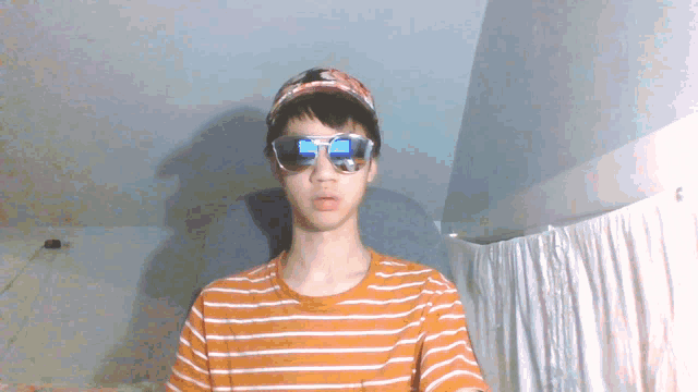 a young man wearing sunglasses and a baseball cap looks at the camera