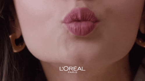 a close up of a woman 's lips with a l' oreal paris logo behind her