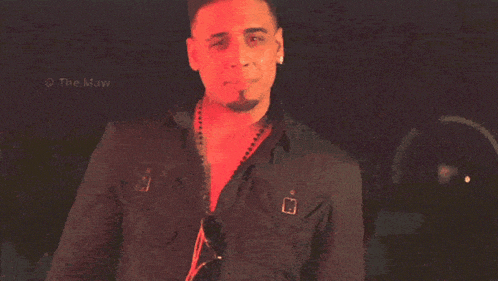 a man in a black shirt is standing in front of a sign that says the maw on it
