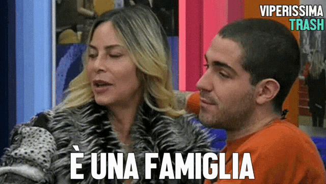 a man and a woman are sitting next to each other with the words e una famiglia written on the bottom