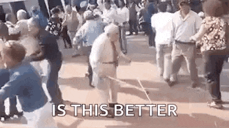 an elderly man is dancing in front of a crowd of people with a stick .