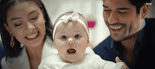 a man and a woman are holding a baby in their arms