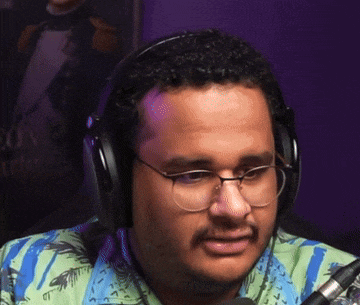 a man wearing headphones and glasses looks at the camera