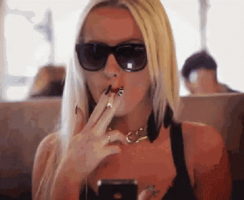 a woman wearing sunglasses is applying lipstick to her lips