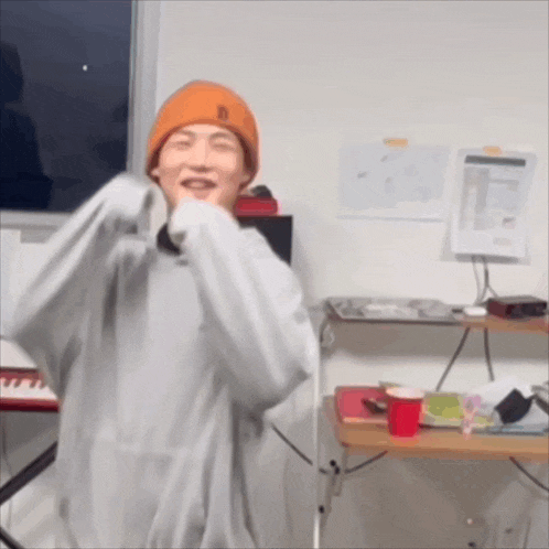 a man wearing an orange beanie with the letter b on it