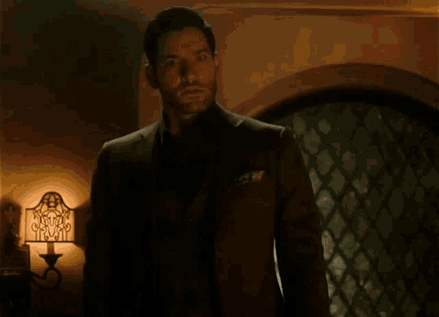 a man and a woman are standing in front of a lamp in a room