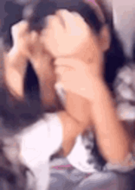a woman is covering her face with her hands while taking a picture of herself .