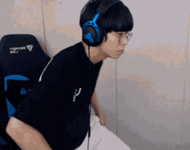 a man wearing headphones and a black shirt with the letter p on the front