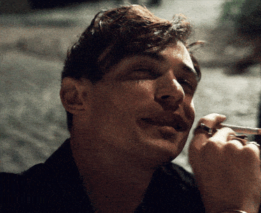 a close up of a man smoking a cigarette