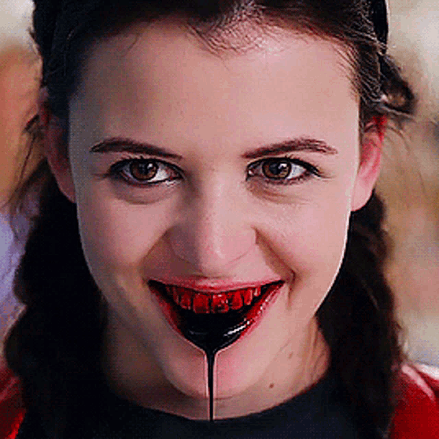 a close up of a woman 's face with a spoon in her mouth