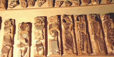 a row of ancient statues with the letter b on one of them
