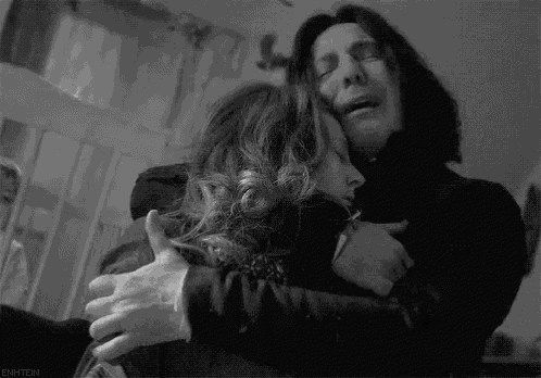 a black and white photo of a man and woman hugging each other .