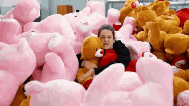 a woman is hugging a teddy bear that says " i love you "