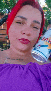 a woman with red hair holds a can of jaws