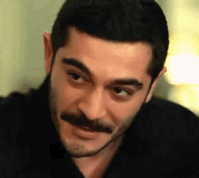 a man with a mustache is making a funny face
